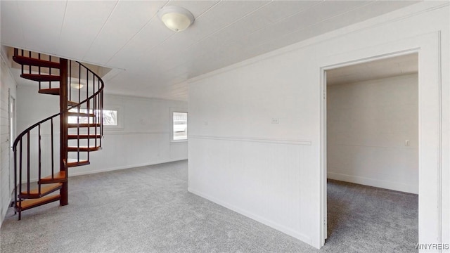 unfurnished room featuring stairway and carpet