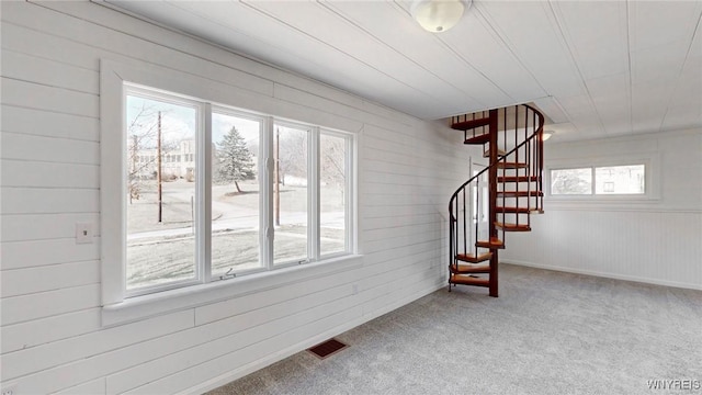 below grade area featuring stairway, visible vents, and carpet floors