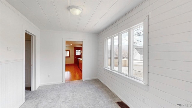 spare room featuring visible vents and light carpet