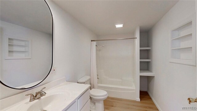 full bathroom with built in features, toilet, wood finished floors, vanity, and shower / bathtub combination with curtain