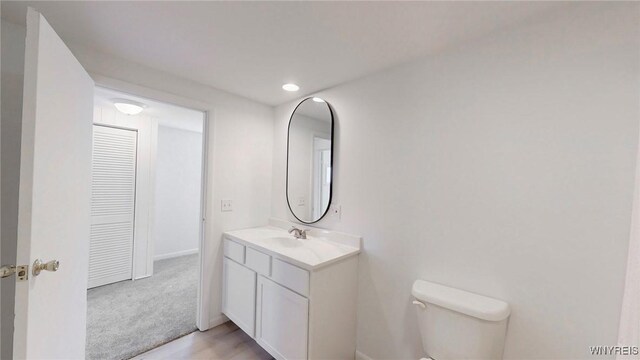 bathroom featuring recessed lighting, toilet, and vanity