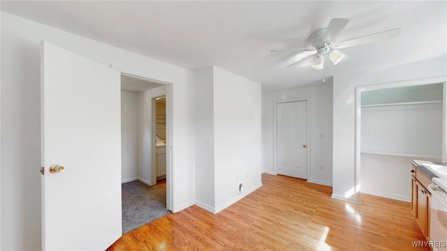 unfurnished bedroom with light wood finished floors, a ceiling fan, and baseboards