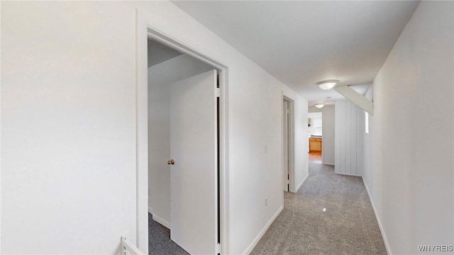 hallway with light colored carpet and baseboards