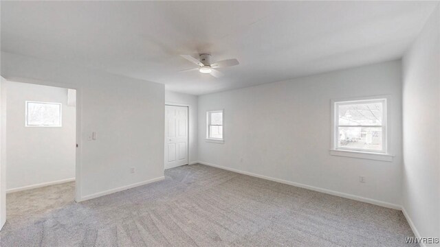 unfurnished room featuring ceiling fan, baseboards, and light carpet