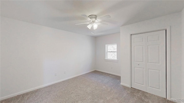 unfurnished bedroom with a closet, ceiling fan, baseboards, and carpet