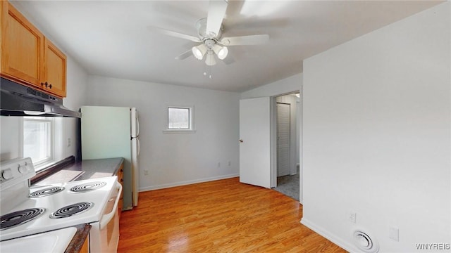 kitchen featuring light wood finished floors, baseboards, ceiling fan, under cabinet range hood, and white appliances