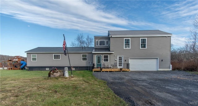 back of property featuring a yard, a playground, a garage, and a deck