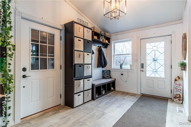 mudroom featuring a notable chandelier and vaulted ceiling