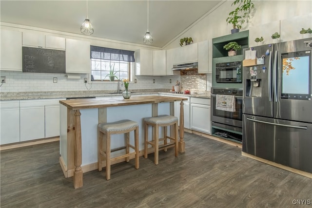 kitchen with appliances with stainless steel finishes, vaulted ceiling, white cabinets, dark hardwood / wood-style floors, and hanging light fixtures