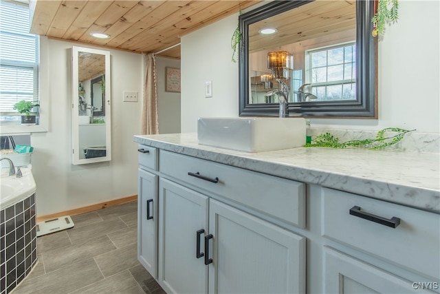 interior space featuring gray cabinetry, light stone counters, wood ceiling, and sink