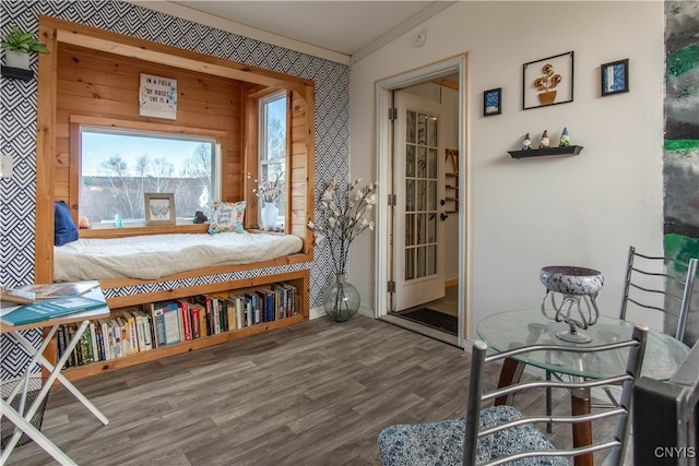 living area with wood walls, ornamental molding, lofted ceiling, and hardwood / wood-style flooring