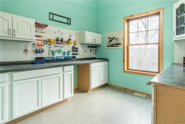 kitchen with backsplash and white cabinetry