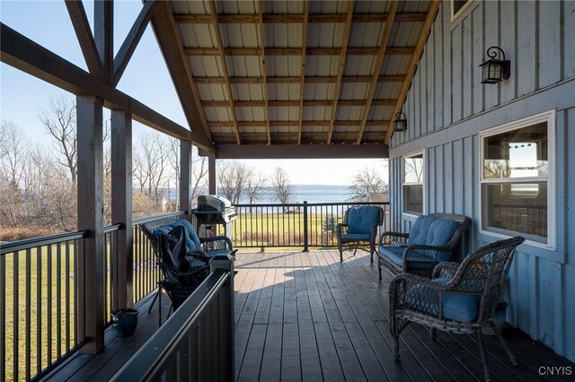 deck with area for grilling and a water view