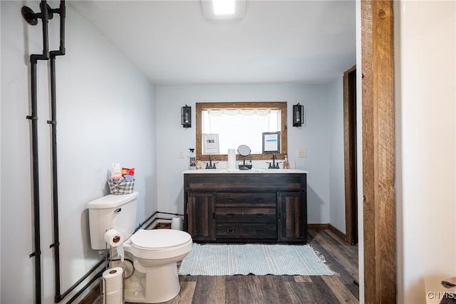 bathroom with wood-type flooring, vanity, and toilet