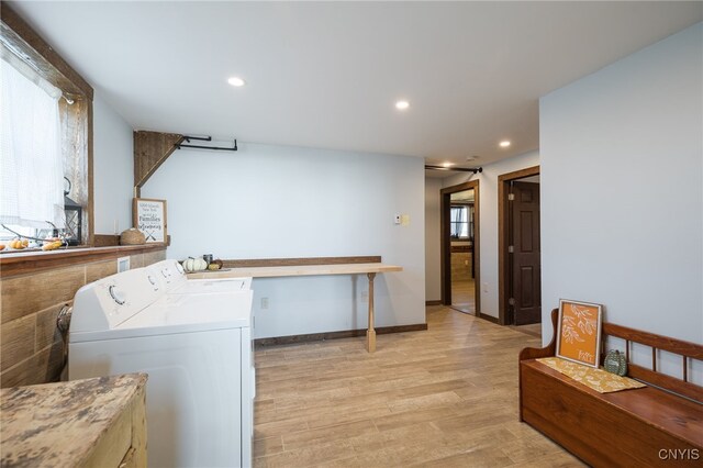 clothes washing area with light hardwood / wood-style flooring and independent washer and dryer