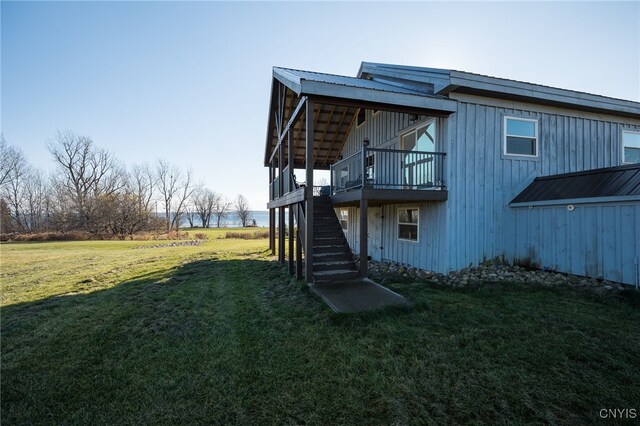 back of property featuring a deck and a lawn