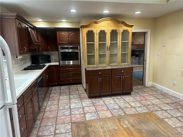 kitchen featuring tasteful backsplash, dark brown cabinetry, black appliances, and custom exhaust hood