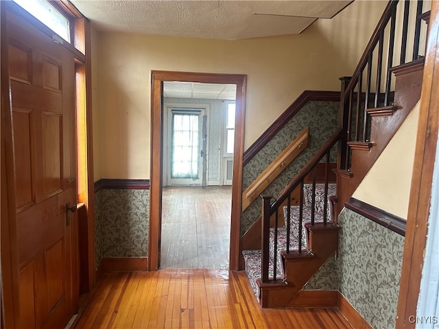 foyer featuring wood-type flooring and a textured ceiling