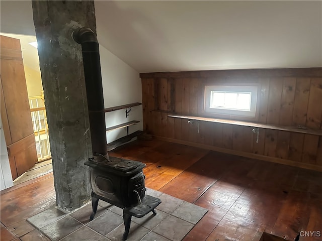 interior space featuring hardwood / wood-style floors, a wood stove, and vaulted ceiling