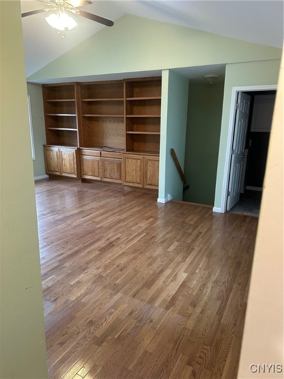 unfurnished living room featuring ceiling fan, lofted ceiling, and dark wood-type flooring