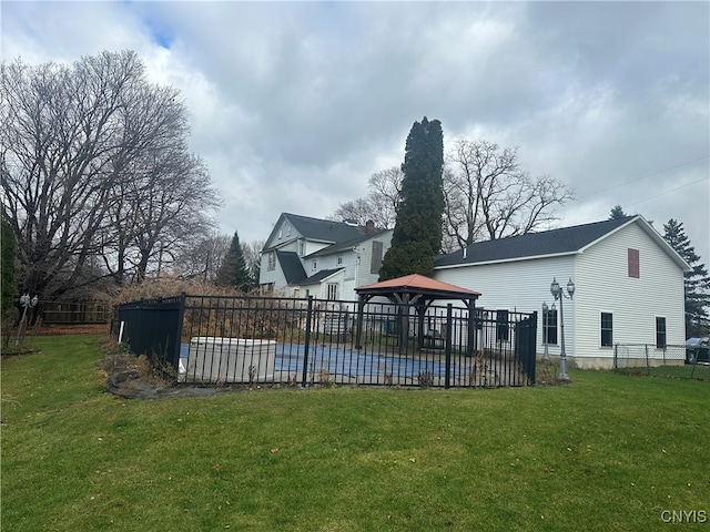 rear view of house featuring a gazebo and a yard