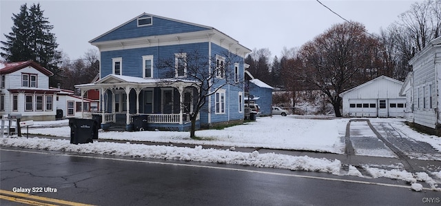 view of front facade with a porch, an outdoor structure, and a garage