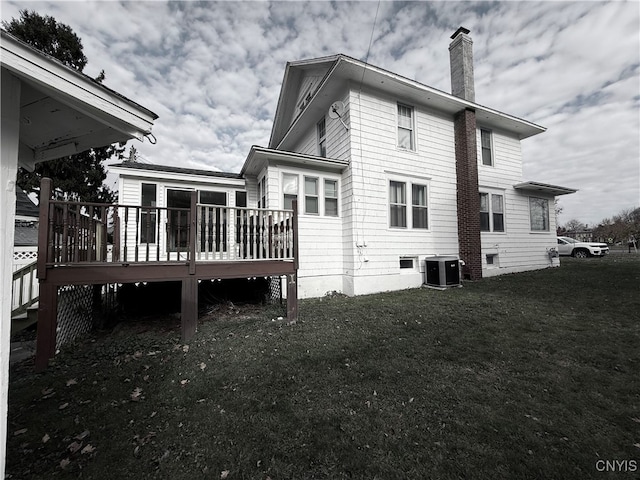 back of property featuring a wooden deck, a lawn, and central air condition unit