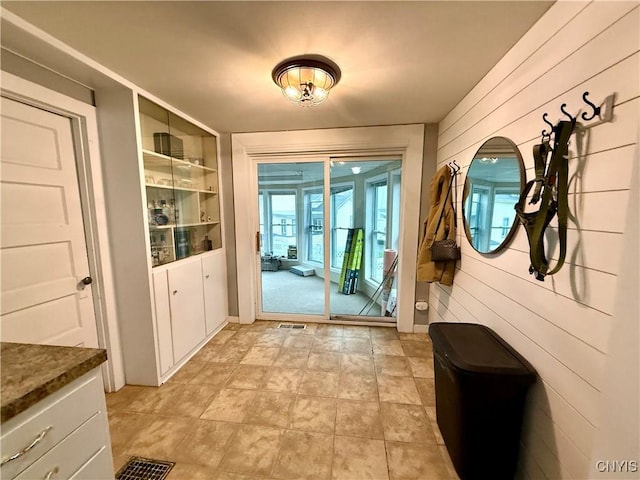 doorway with built in shelves and wooden walls