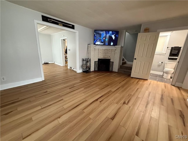 unfurnished living room featuring a fireplace and light hardwood / wood-style floors