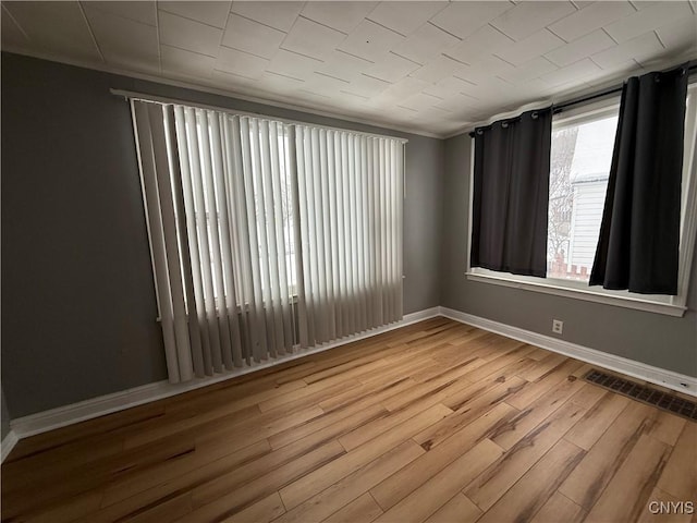 spare room featuring hardwood / wood-style flooring and crown molding