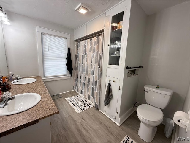 bathroom with vanity, hardwood / wood-style floors, walk in shower, and toilet