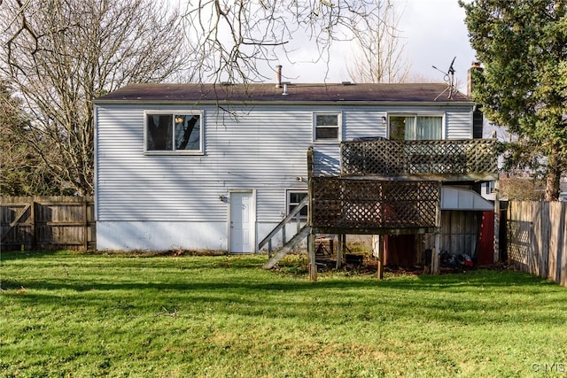 rear view of property featuring a yard and a deck