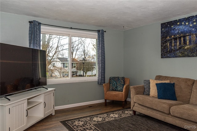 living room featuring dark wood-type flooring and a textured ceiling