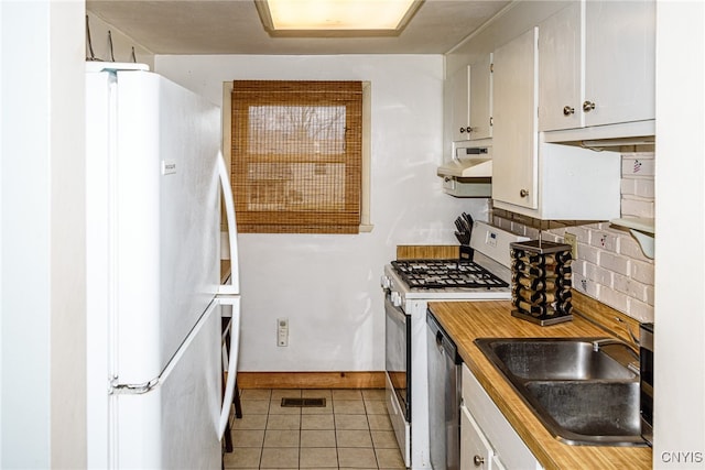 kitchen with white cabinetry, sink, decorative backsplash, light tile patterned flooring, and appliances with stainless steel finishes