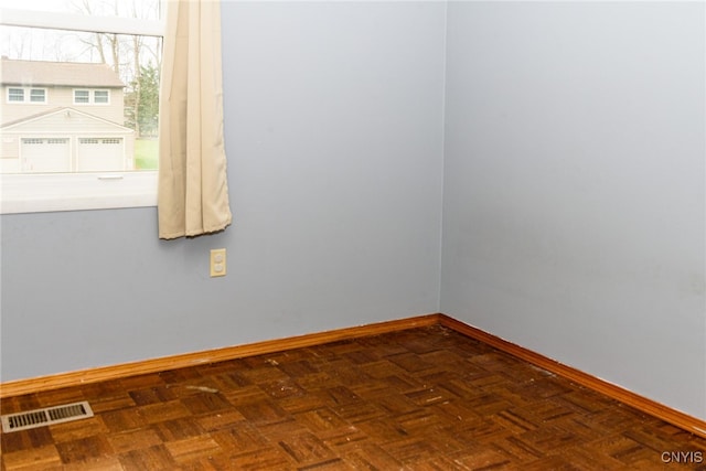 spare room with dark parquet floors