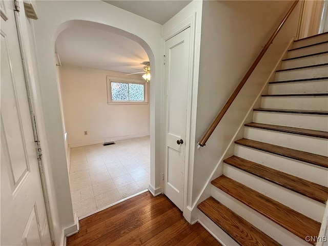 stairway with ceiling fan and hardwood / wood-style flooring