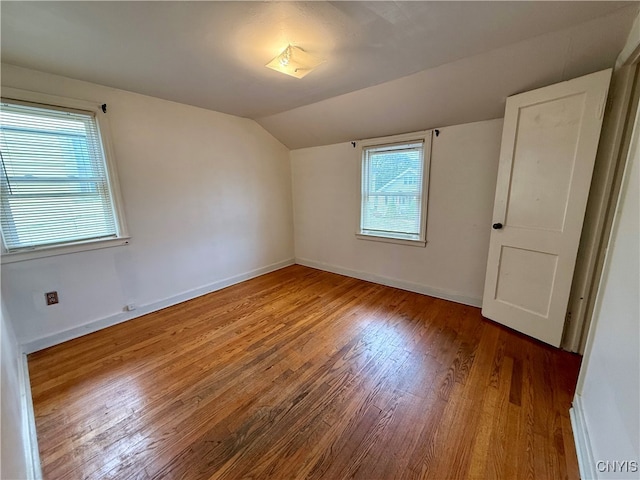 additional living space with hardwood / wood-style floors and lofted ceiling