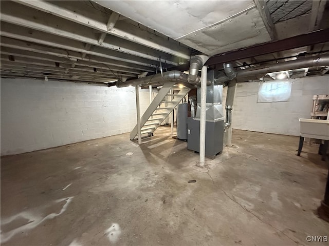 basement with sink, heating unit, and water heater