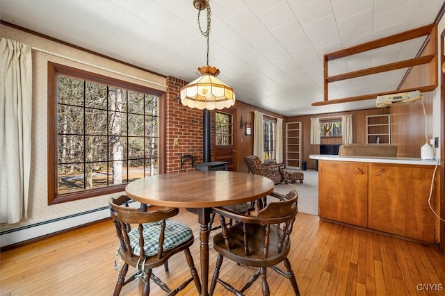 dining area featuring a wood stove and light hardwood / wood-style flooring