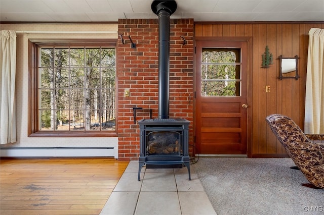 interior space with wooden walls, a healthy amount of sunlight, a baseboard radiator, and light hardwood / wood-style floors