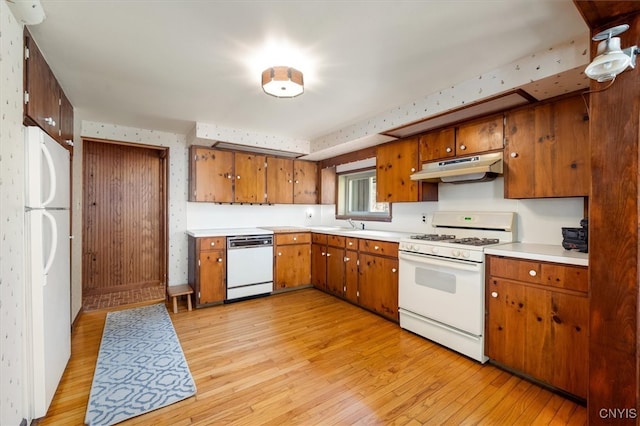 kitchen with light hardwood / wood-style flooring and white appliances