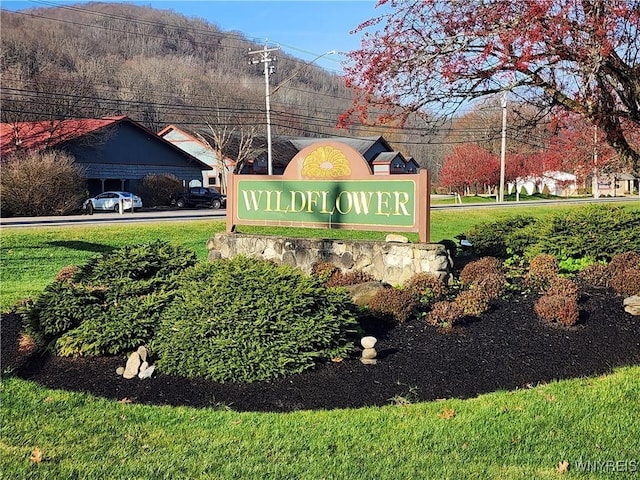 community / neighborhood sign featuring a lawn