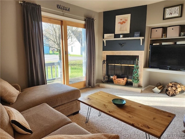 living room with a tiled fireplace and carpet