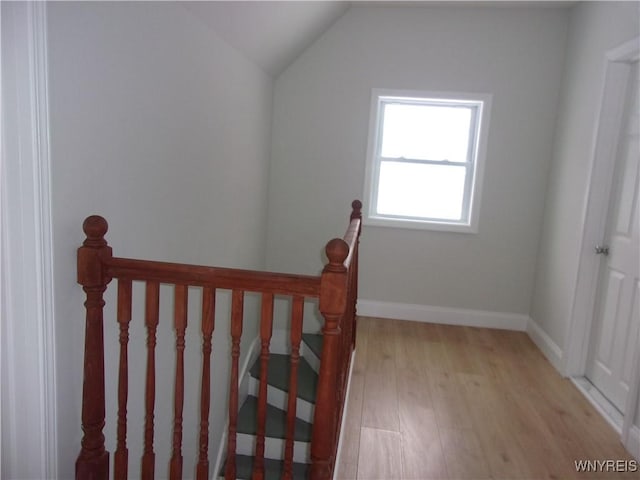 stairs with hardwood / wood-style floors and lofted ceiling