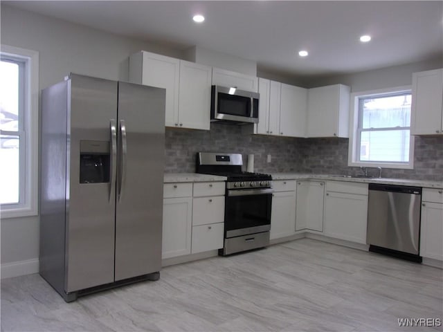 kitchen featuring white cabinets, sink, appliances with stainless steel finishes, and tasteful backsplash