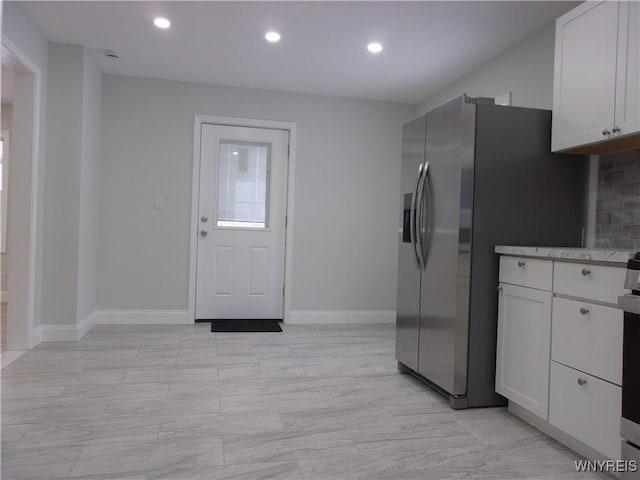 kitchen featuring white cabinets and stainless steel fridge with ice dispenser