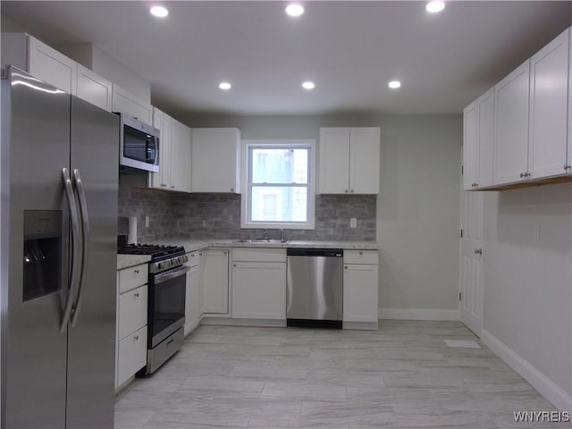 kitchen with white cabinets, backsplash, stainless steel appliances, and sink