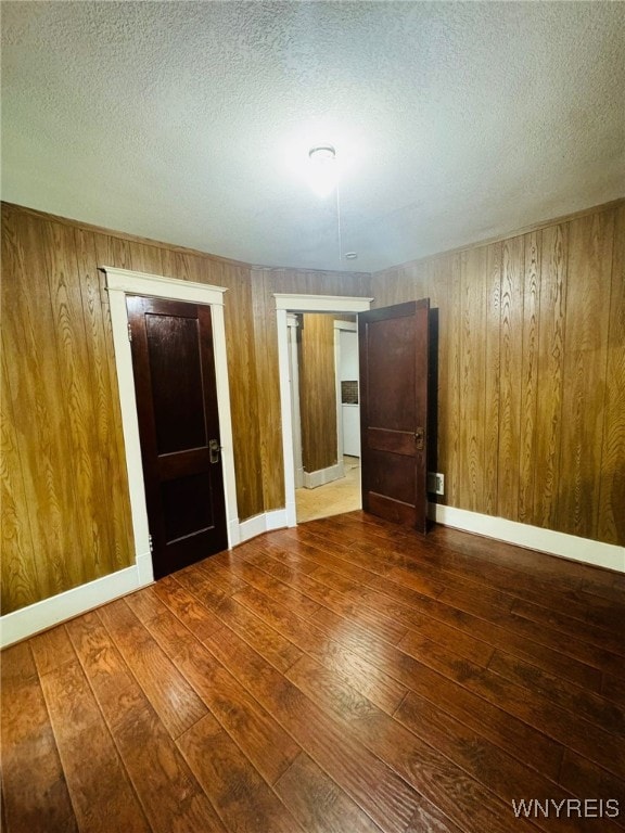 empty room with a textured ceiling and hardwood / wood-style flooring