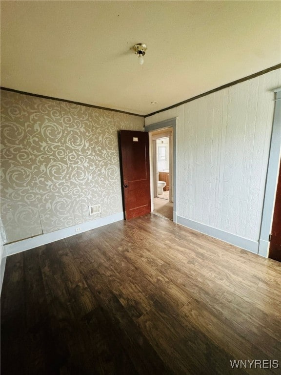 spare room featuring wood-type flooring and ornamental molding