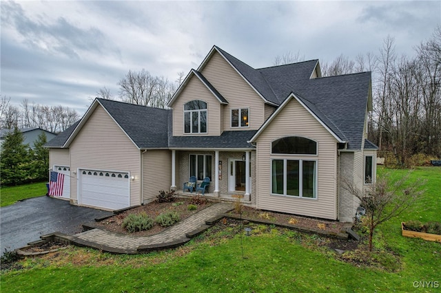 front facade featuring a front yard, a porch, and a garage